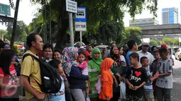 Warga menunggu kedatangan Bus City Tour Jakarta di halte Masjid Istiqlal, Jakarta, Sabut (26/12/2015). Sejumlah warga memanfaatkan waktu Libur berkeliling Jakarta dengan Bus City Tour. (Liputan6.com/Yoppy Renato)