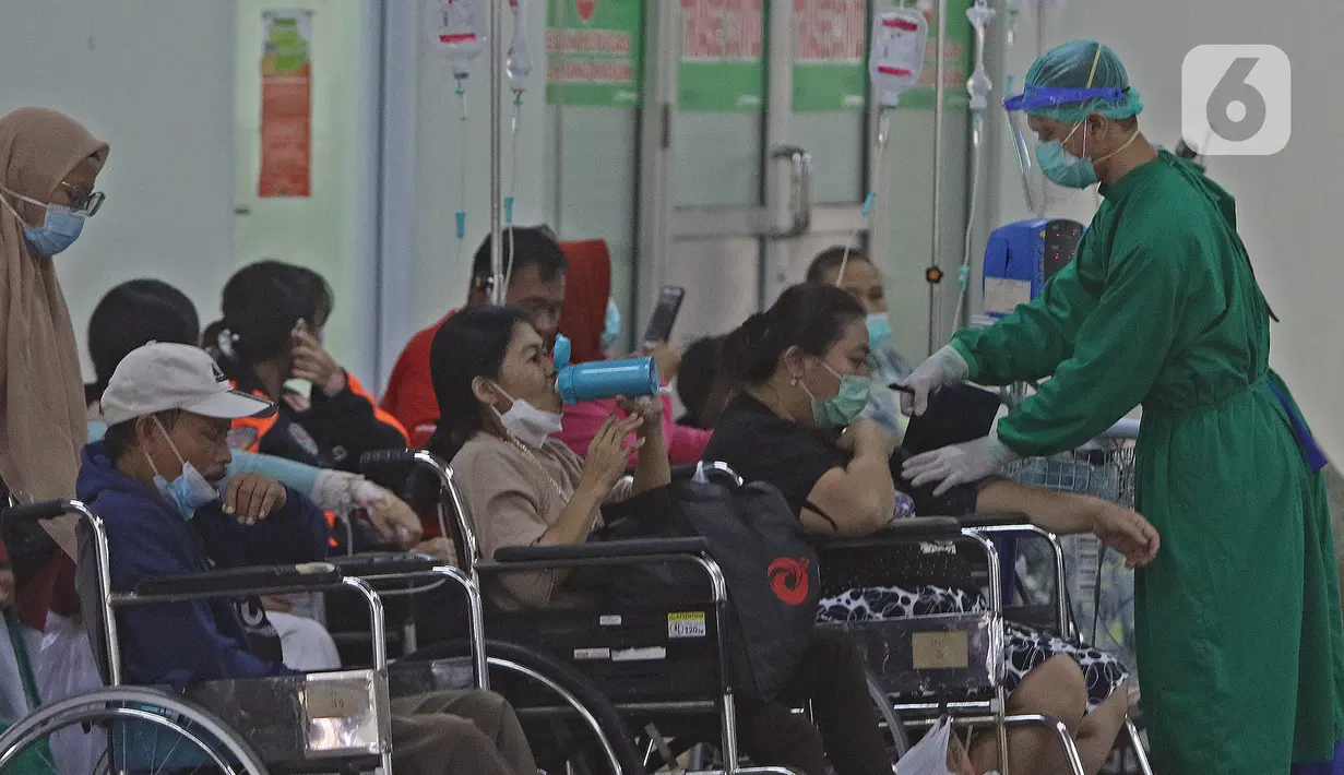 Petugas medis (kanan) memeriksa kondisi pasien di IGD RSUD Cengkareng, Jakarta, Rabu (23/6/2021). Meningkatnya kasus COVID-19 di Ibu Kota Jakarta dalam beberapa hari terakhir mengakibatkan rumah sakit kewalahan. (Liputan6.com/Herman Zakharia)