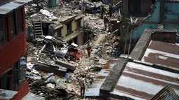 Sejumlah warga berjalan di reruntuhan puing bangunan pasagempa susulan berkekuatan 7,3 SR melanda Sankhu, Nepal, Selasa (12/5/2015). Sebelumnya, luka atas gempa dahsyat yang terjadi 25 April lalu di Nepal masih belum terobati. (REUTERS/Navesh Chitrakar)
