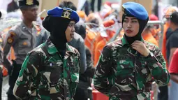 Dua aparat TNI wanita berjaga saat Hari Buruh Sedunia di depan Istana Negara, Jakarta, Selasa (1/5). Memperingati Hari Buruh 2018, ribuan buruh mulai memadati Istana Kepresidenan, Jakarta Pusat. (Liputan6.com/Johan Tallo)