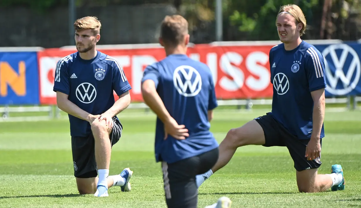 Pemain Jerman Timo Werner (kiri) dan Julian Brandt (kanan) melakukan peregangan saat sesi latihan di pusat olahraga BVSC, Budapest, Hungaria, 13 Juni 2022. Jerman akan menghadapi Italia pada pertandingan sepak bola UEFA Nations League. (Attila KISBENEDEK/AFP)