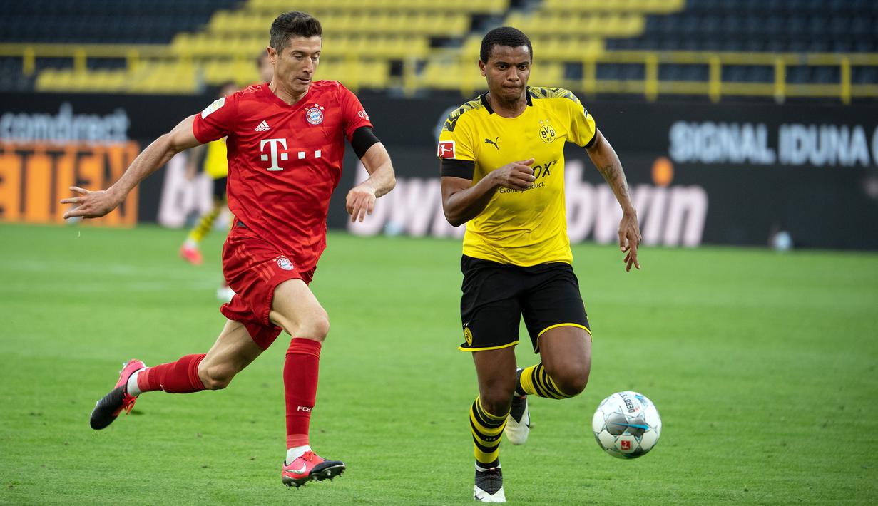 Striker Bayern Munchen, Robert Lewandowski, berebut bola dengan bek Borussia Dortmund, Manuel Akanji, pada laga pekan ke-28 Bundesliga di Stadion Signal Iduna Park, Selasa (26/5/2020) waktu setempat. Bayern Munchen menang 1-0 atas Borussia Dortmund. (AFP/Federico Gambarini/Pool)