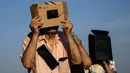 Warga menggunakan filter las untuk menyaksikan bulan melintasi cakrawala matahari saat gerhana matahari sebagian di Bene Vagienna, dekat Turin, Italia barat laut, Rabu, 12 Agustus 2026.(AFP/ Marco Bertorello)