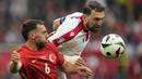 Bek Timnas Georgia, Guram Kashia (kanan) berduel udara dengan gelandang Timnas Turki, Orkun Kokcu pada laga matchday pertama Grup F Euro 2024 di Westfalenstadion, Dortmund, Jerman, Selasa (18/6/2024). (AP Photo/Martin Meissner)