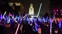 Penggemar film Star Wars berkumpul sambil membawa lightsaber (pedang sinar) saat mengikuti Glow Battle Tour di Grand Park, Los Angeles (15/12). (Photo by Chris Pizzello/Invision/AP)