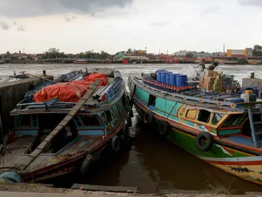 Pekerja mengangkut barang ke kapal di kawasan Dermaga 16 Ilir di tepian Sungai Musi, Palembang, Sumatera Selatan, Rabu (28/5/2025). (Liputan6.com/Herman Zakharia)