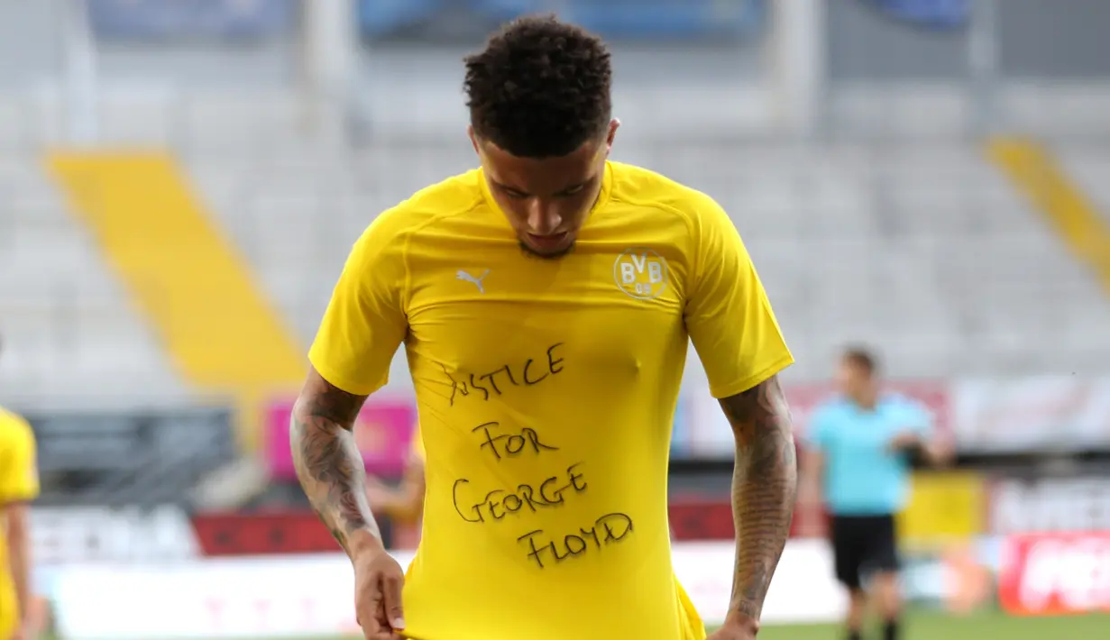 Gelandang Borrusia Dortmund, Jadon Sancho berselebrasi menunjukkan tulisan di kaos dalam 'Justice for George Floyd' usai mencetak gol ke gawang SC Paderborn 07 di Benteler Arena di Paderborn, Jerman (1/6/2020). Dalam pertandingan ini Dortmund menang telak 6-1 atas Paderborn. (Lars Baron/Pool via AP)