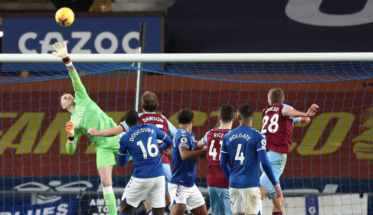 Kiper Everton, Jordan Pickford (kiri) terbang menepis tandukan gelandang West Ham United, Tomas Soucek (kanan) dalam laga lanjutan Liga Inggris 2020/21 pekan ke-17 di Goodison Park, Jumat (1/1/2021). Everton kalah 0-1 dari West Ham United. (AFP/Jan Kruger/Pool)