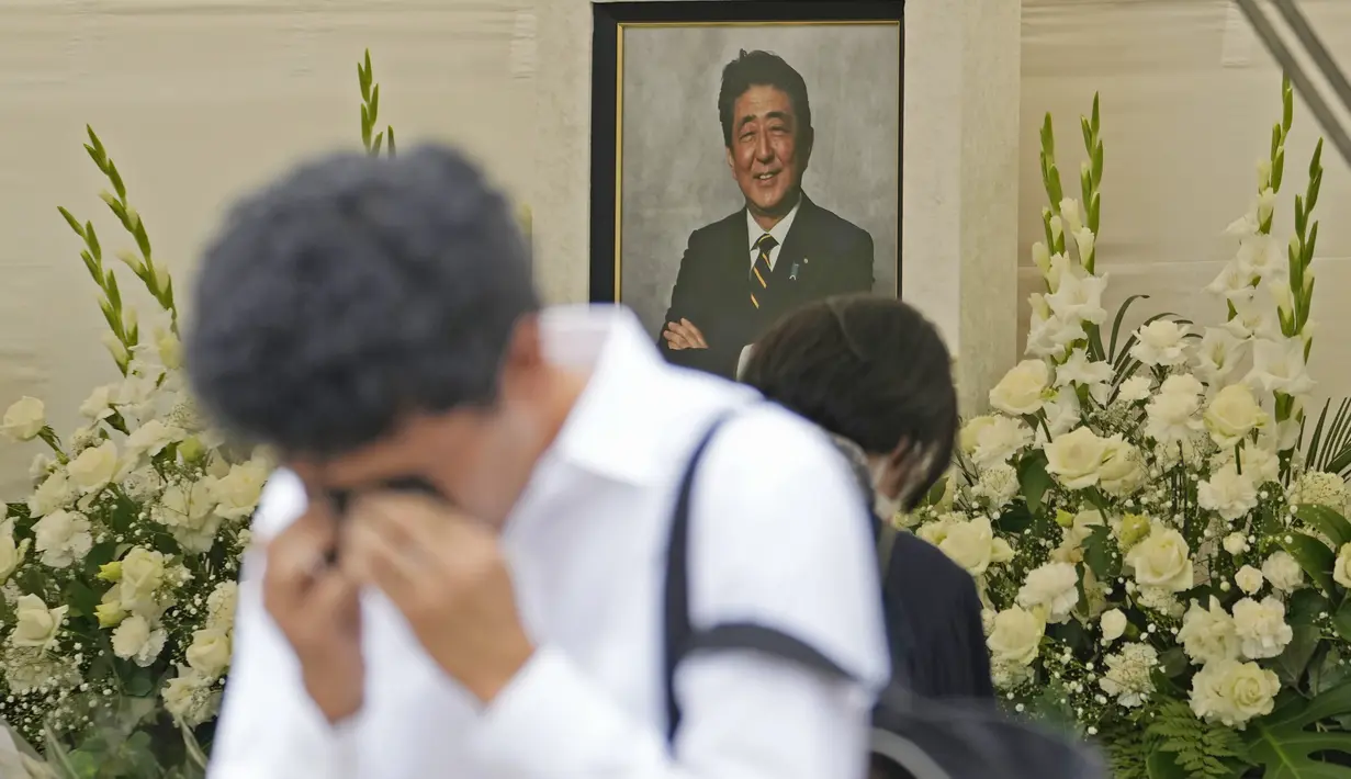 Reaksi seorang pria setelah memberi bunga dan doa untuk mantan Perdana Menteri Jepang Shinzo Abe di kuil Zojoji, Tokyo, Sabtu (8/7/2023). (AP Photo/Shuji Kajiyama)