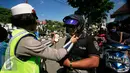 Seorang Polwan mengancingkan tali helm pada operasi lalu lintas di Abu Bakar Ali,Yogyakarta, (19/5). Operasi ini untuk menekan angka kecelakaan, petugas memberikan surat tilang di tempat kepada pelanggar lalu lintas. (Liputan6.com/Boy Harjanto)