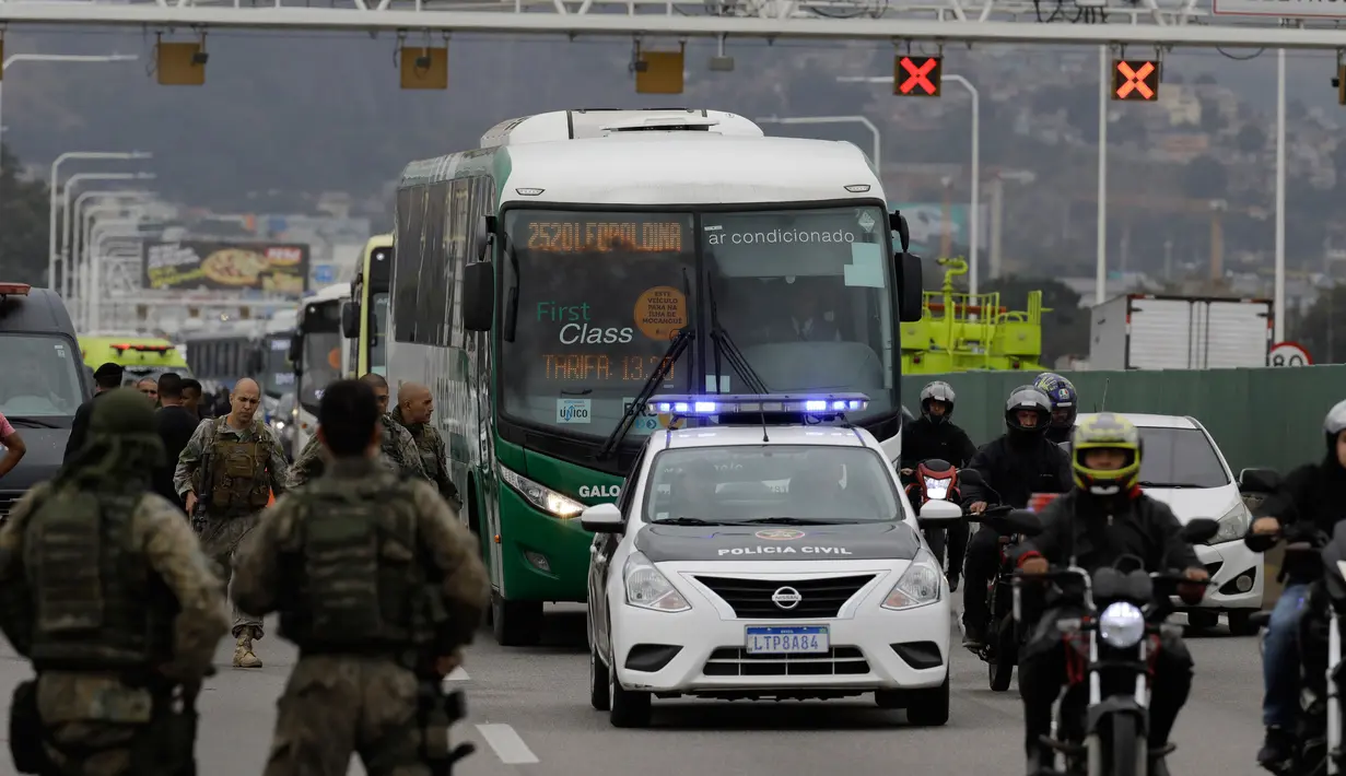 Polisi mengawal bus yang disandera oleh seorang pria bersenjata di jembatan yang menghubungkan Kota Niteroi dengan Rio de Janeiro, Brasil, Selasa (20/8/2019). Polisi menduga penyandera  memiliki masalah psikologis. (AP Photo/Leo Correa)