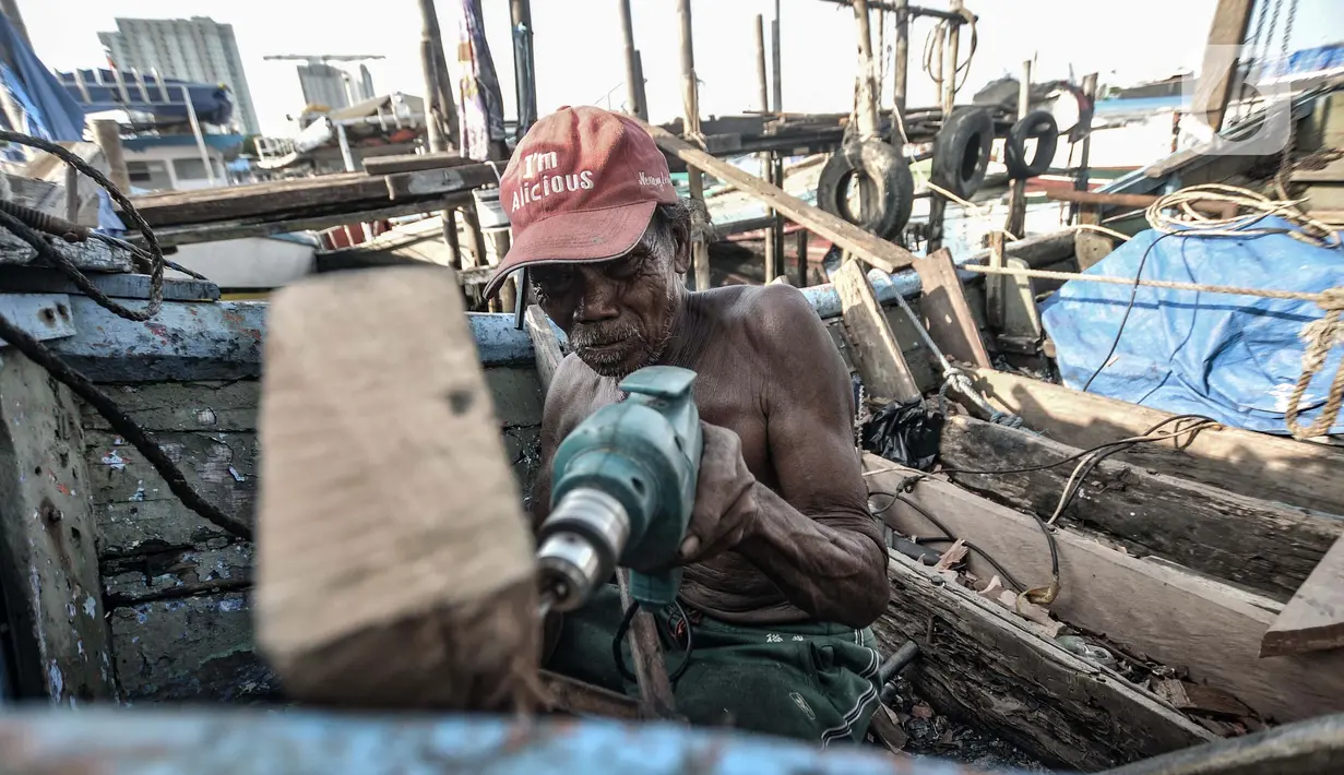 Syamsudin (71) saat menyelesaikan perbaikan kapal nelayan di kawasan Sunda Kelapa, Jakarta, Rabu (17/3/2021). Dalam membuat atau memperbaiki kapal, Syamsudin bekerja hanya seorang diri dengan mengandalkan keahliannya yang dimulai sejak pagi hingga sore hari. (merdeka.com/Iqbal S. Nugroho)