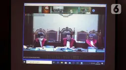 Layar menayangkan Majelis Hakim membacakan putusan terhadap mantan anggota DPR Sukiman dalam sidang secara online di Gedung KPK, Jakarta, Rabu (29/4/2020). Sukiman diduga menerima suap terkait pengurusan dana perimbangan APBN-P 2017 dan APBN 2018 Kabupaten Pegunungan Arfak. (merdeka.com/Dwi Narwoko)