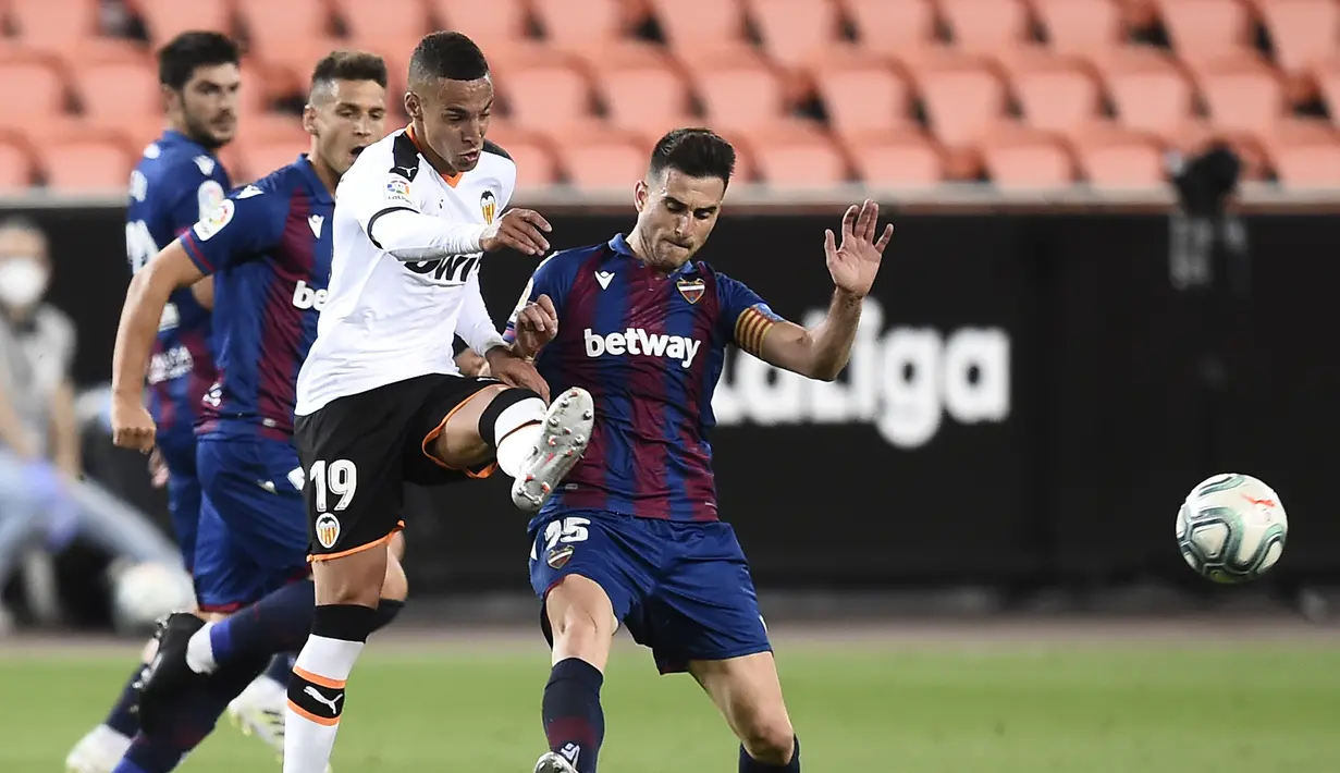 Penyerang Valencia, Rodrigo Moreno, berebut bola dengan bek Levante, Sergio Postigo, pada laga pekan ke-28 Liga Spanyol di Stadion Mestalla, Sabtu (13/6/2020) dini hari WIB. Valencia bermain imbang 1-1 atas Levante. (AFP/Jose Jordan)