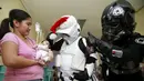 Sejumlah orang berpakaian karakter Star Wars saat menghibur bayi yang sedang dirawat disalah satu rumah sakit yang berada di Manila, Filipina, (6/12). Ini merupakan kegiatan amal yang dibuat oleh Organisasi 501 Legiun. (REUTERS/Romeo Ranoco)