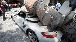 Bangunan yang menghantam sebuah mobil setelah gempa mengguncang Kota Meksiko (19/9). Sekitar 100 orang tewas dalam bencana gempa bumi 7,1 Skala Richter tersebut. (AFP Photo/Alfredo Estrella)
