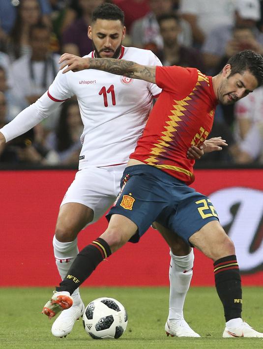 Pemain Spanyol, Isco (depan) berusaha keluar dari tekanan pemain Tunisia, Dylan Bronn pada laga uji coba di Krasnodar stadium, Rusia, (9/6/2018). Spanyol menang 1-0. (AP/STR)