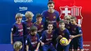 Gelandang baru Barcelona, Philippe Coutinho foto bersama dengan anak-anak saat perkenalan dirinya di Nou Camp, Barcelona (8/1). Coutinho diboyong Barcelona dengan harga sebesar 400 juta euro (sekitar Rp 6,45 triliun). (AFP Photo/Lluis Gene)