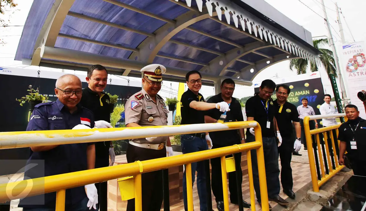 Direktur Keamanan dan Keselamatan Koordinator Lalulintas, Chryshnanda Dwilaksana (ketiga kiri) bersama Presdir PT Astra International Tbk Prijono Sugiarto (keempat kiri) mengecat pagar halte Lapangan Panah, Senayan, Jakarta (25/2). (Liputan6.com)