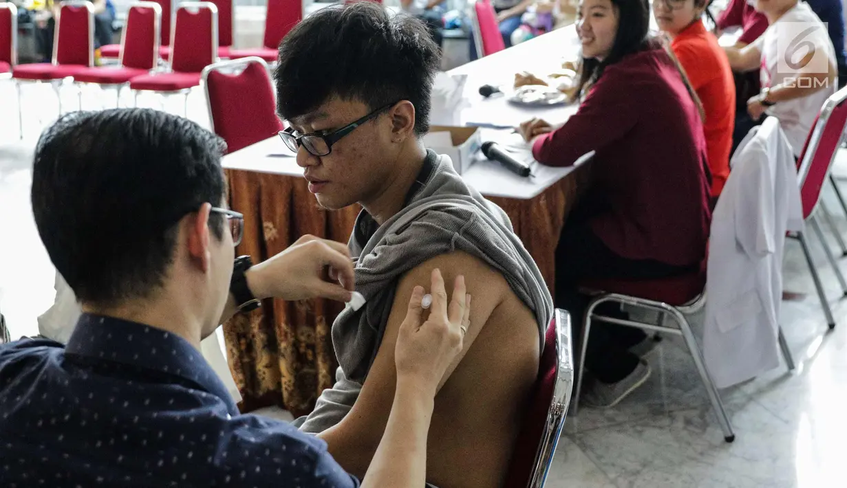 Seorang mahasiswa saat disuntik vaksin difteri di Universitas Tarumanegara, Jakarta, Kamis (14/5). Ratusan mahasiswa/wi yang berusia di bawah 19 tahun mendapatkan imunisasi (Td) sebagai antisipasi mewabahnya penyakit difteri. (Liputan6.com/Faizal Fanani)