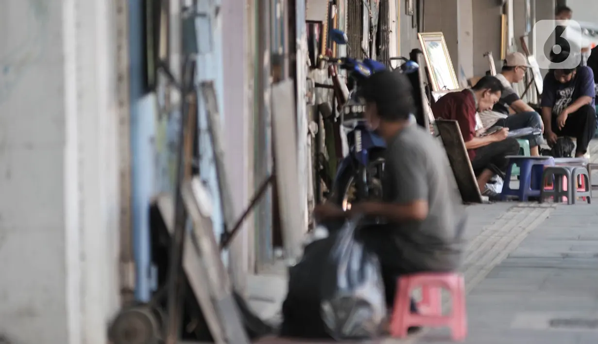Seniman lukis menyelesaikan karyanya di pinggir Jalan Pintu Besar Selatan, Pinangsia, Jakarta, Selasa (2/6/2020). Sejumlah seniman memilih tutup sementara di tengah pandemi virus corona COVID-19, sedangkan beberapa lainnya tetap bertahan demi mendapatkan penghasilan. (merdeka.com/Iqbal S. Nugroho)