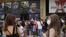 Orang-orang mengantre di toko resmi PSG untuk membeli jersey bertuliskan nama Lionel Messi di stadion Parc des Princes di Paris, Rabu (11/8/2021). Penjualan jersey PSG dengan nama Messi dan nomor punggung 30 laris manis, bahkan fans rela antre panjang. (AP Photo/Francois Mori)