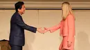 Ivanka Trump (kanan) berjabat tangan dengan PM Shinzo Abe saat acara Majelis Wanita Sedunia (WAW!) di Tokyo, Jepang (3/11). Ivanka berpidato di Majelis Wanita Sedunia jelang kunjungan luar negeri ayahnya ke Jepang. (AFP Photo/Pool/Eugene Hoshiko)