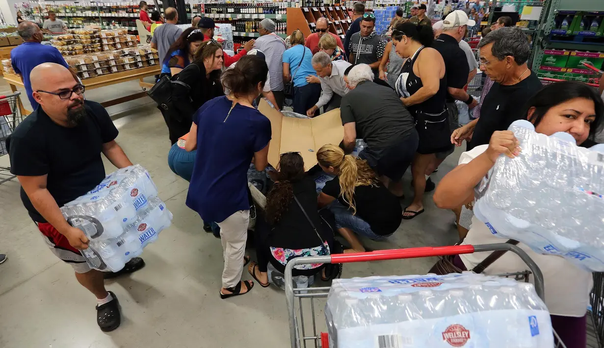 Pelanggan memborong air mineral di BJ Wholesale, Miami, Selasa (5/9). Pasca Florida mengumumkan keadaan darurat menjelang kedatangan badai Irma, warga menyerbu toko untuk memenuhi stok barang kebutuhan mereka. (Roberto Koltun/Miami Herald via AP)