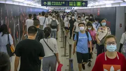 Orang-orang yang memakai masker berjalan melalui stasiun kereta bawah tanah pada jam sibuk pagi hari di Beijing, Rabu (4/8/2021). Wabah virus corona terparah di China sejak awal pandemi satu setengah tahun lalu meningkat pada Rabu dengan lusinan kasus lagi di seluruh negeri. (AP/Mark Schiefelbein)