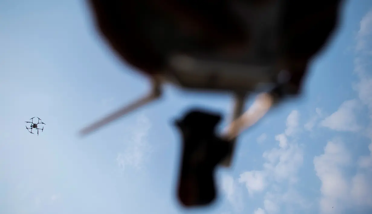 Sebuah drone untuk menurunkan hujan buatan terbang saat demontrasi di Bangkok, Kamis (31/1). Thailand melakukan operasi pengurangan polusi udara dengan menggunakan drone untuk menurunkan hujan buatan dengan cara menyemprotkan bahan kimia (Jewel SAMAD/AFP)