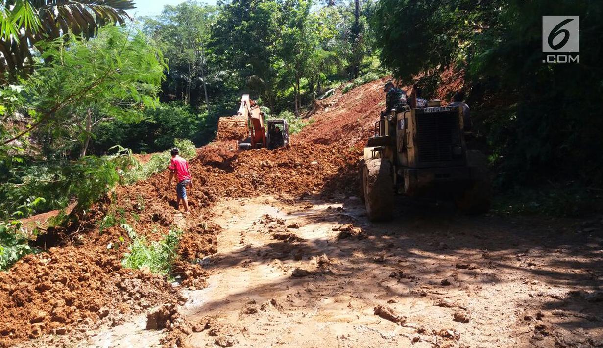 Petugas menggunakan alat berat untuk melakukan pengurukan material longsor di ruas Ciwidey-Cidaun, Kabupaten Cianjur, Jawa Barat (27/4). Tak ada korban jiwa maupun luka dalam bencana longsor tersebut. (Liputan6.com/Ahmad Sudarno)