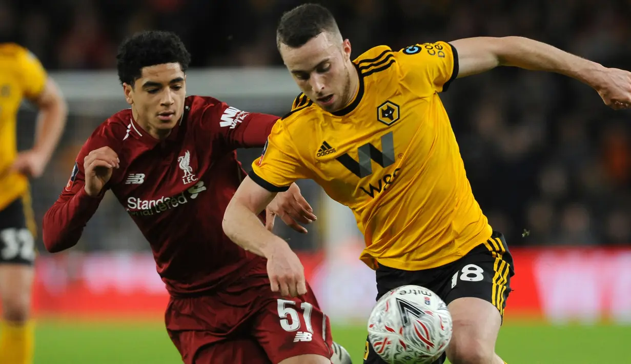 Pemain Liverpool, Ki-Jana Hoever merebut bola dari pemain  Wolverhampton Wanderers, Diogo Jota pada laga putaran ketiga Piala FA di Molineux Stadium, Senin (7/1). Liverpool tersingkir dari Piala FA setelah takluk 1-2 dari Wolverhampton. (AP/Rui Vieira)