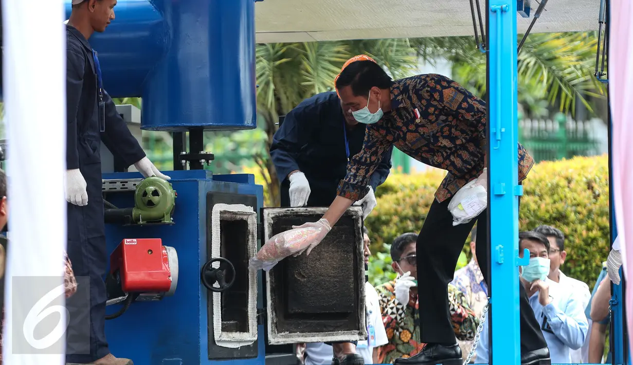 Presiden Jokowi memasukkan barang bukti narkoba yang berhasil dijaring BNN untuk dimusnahkan ke dalam mesin di Monas, Jakarta, Selasa (6/12). Ini merupakan pemusnahan narkoba yang berhasil dijaring BNN selama 2 bulan terakhir. (Liputan6.com/Faizal Fanani)