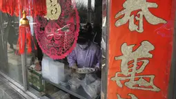 Seorang pekerja mengemas pangsit untuk pelanggan di sebuah restoran selama hari titik balik matahari musim dingin di Beijing, China, Selasa (21/12/2021). Pangsit adalah makanan festival selama hari titik balik matahari musim dingin. (AP Photo/Ng Han Guan)