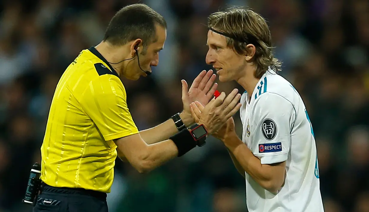 Pemain Real Madrid Luka Modric melakukan protes terhadap wasit saat melawan Bayern Munchen dalam pertandingan semifinal Liga Champions di stadion Santiago Bernabeu, Spanyol (1/5). (AP/Paul White)