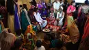 Sejumlah pasangan pengantin menjalani ritual dalam prosesi pernikahan massal umat Hindu di Karachi, Pakistan, (19/3). Sebanyak 62 pasangan pengantin mengikuti pernikahan massal yang merupakan bagian dari perayaan Festival Holi. (AFP Photo /Asif Hassan)