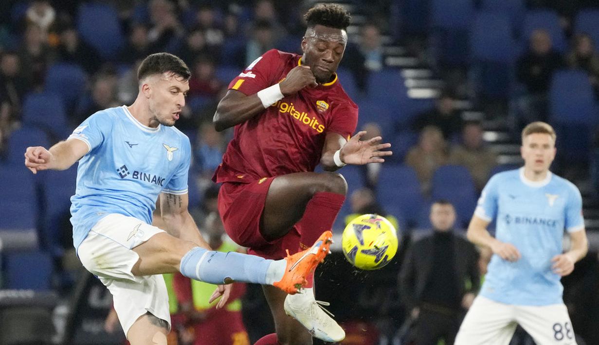 Pemain Lazio, Nicolo Casale, berebut bola dengan pemain AS Roma, Tammy Abraham, pada laga pekan ke-27 Serie A 2022/2023 di Stadion Olimpico, Senin (20/03/2023). Lazio menang dengan skor 1-0. (AP Photo/Gregorio Borgia)