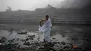 Seorang pria mengambil air di sungai Bagmati untuk melakukan ritual selama Festival Gaya Aunsi di Kathmandu, Nepal (21/12). (AP Photo/Niranjan Shrestha)