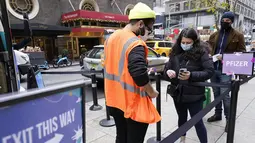 Pekerja kesehatan memeriksa orang-orang di klinik vaksin keliling NYC di Midtown Manhattan, Senin (6/12/2021). Wali Kota Bill de Blasio mengumumkan semua pengusaha swasta Kota New York harus mewajibkan pekerja mereka untuk divaksinasi COVID-19 mulai 27 Desember. (AP Photo/Mary Altaffer)