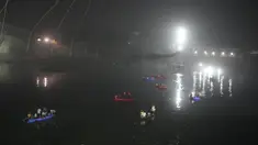 Tim penyelamat di kapal mencari di sungai Machchu di sebelah jembatan kabel yang runtuh di kota Morbi di negara bagian barat Gujarat, India, Senin, 31 Oktober 2022. Jembatan gantung kabel berusia seabad runtuh ke sungai Minggu malam, menyebabkan ratusan orang terjun. di dalam air, kata para pejabat. (AP/Ajit Solanki)