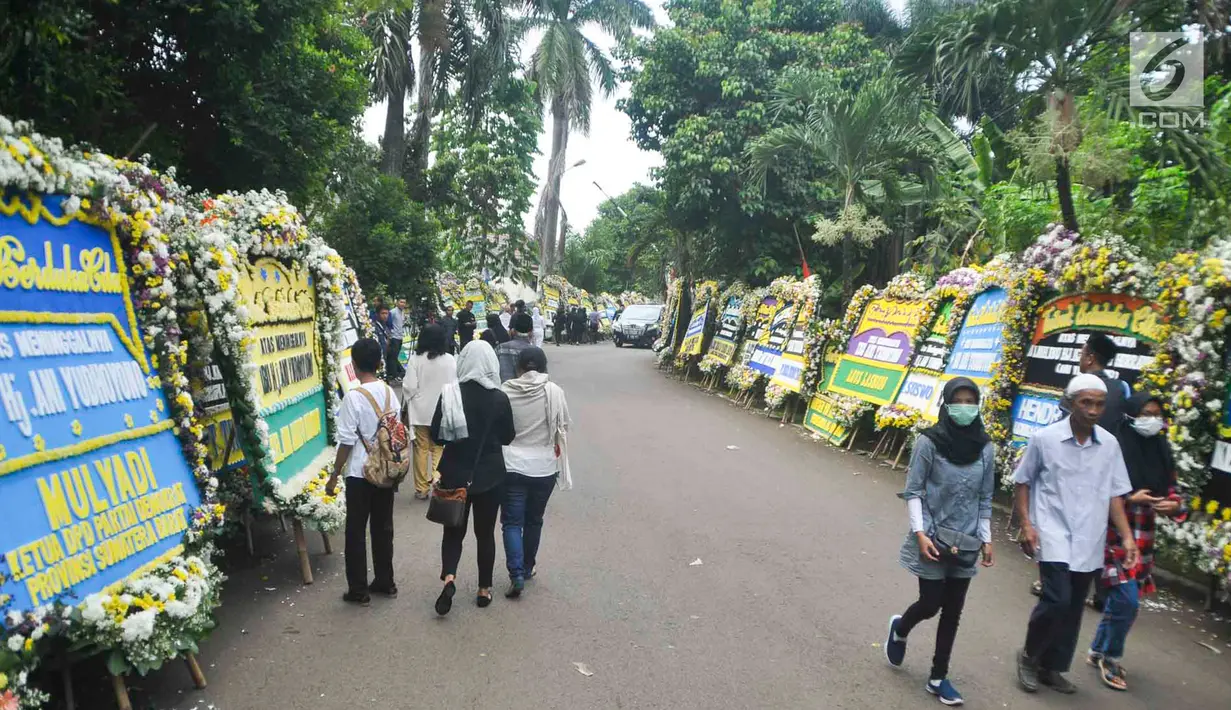 Warga berjalan di sekitar tempat persemayaman Ani Yudhoyono di Puri Cikeas, Bogor, Jawa Barat, Minggu (2/6/2019). Ani Yudhoyono akan dimakamkan di TMP Kalibata pada pukul 15.00 WIB.(Liputan6.com/Immanuel Antonius)