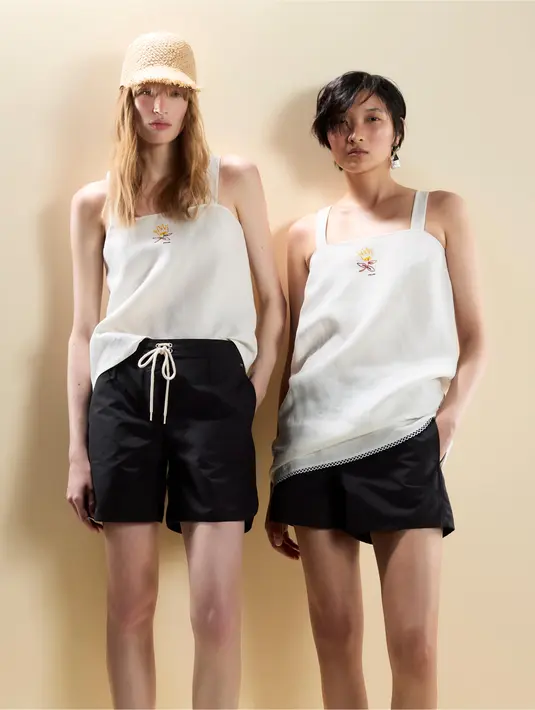 Pantai di tengah kota—hamparan pasir yang seolah berada di atas gedung pencakar langit, menghadirkan sensasi berenang di udara. Kontras yang tak lazim ini menjadi ciri khas identitas Prada