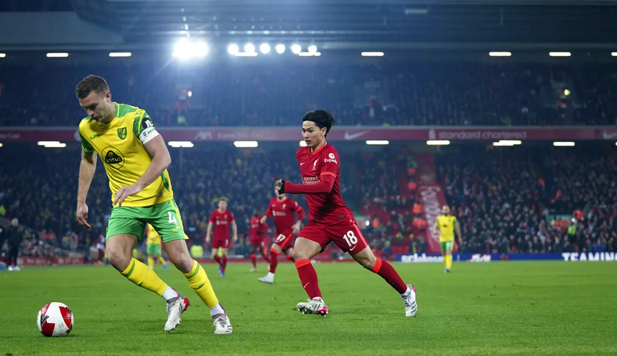 Pemain Liverpool Takumi Minamino (kanan) berebut bola dengan pemain Norwich City Ben Gibson pada pertandingan sepak bola Piala FA di Stadion Anfield, Liverpool, Inggris, 2 Maret 2022. Liverpool menang 2-1. (AP Photo/Jon Super)