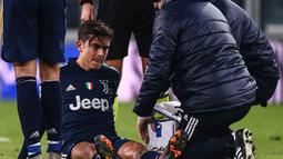 Striker Juventus, Paulo Dybala mendapat penanganan dari tim medis usai mengalami cedera dalam laga lanjutan Liga Italia Serie A 2020/21 pekan ke-17 melawan Sassuolo di Juventus Stadium, Minggu (10/1/2021). Juventus menang 3-1 atas Sassuolo. (AFP/Marco Bertorello)
