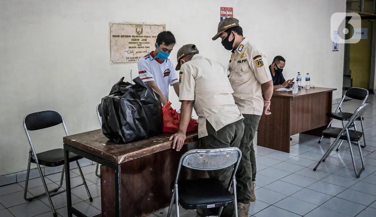 Petugas Satpol PP mengecek tempat karantina untuk pendatang tanpa SIKM di Gedung Auditorium Gelanggang Remaja Gambir, Jakarta, Rabu (27/5/2020). (Liputan6.com/Faizal Fanani)