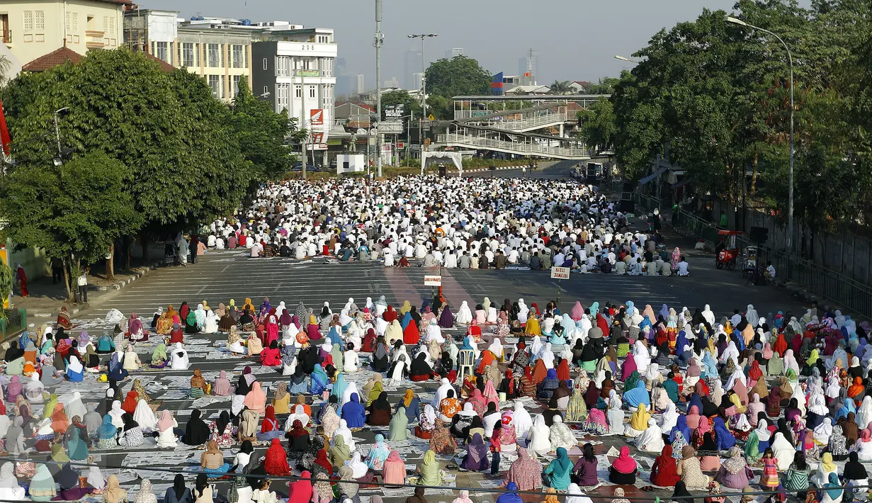 Umat Muslim di kawasan Jatinegara dan sekitarnya melaksanakan sholat Idul Adha 1436 H, Jakarta, Kamis (24/9/2015). Ruas Jalan Jatinegara Barat disulap menjadi tempat pelaksanaan salat. (Liputan6.com/Yoppy Renato)