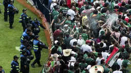 Fans Meksiko melepaskan semprotan busa saat merayakan kemenangan timnya atas Jerman pada laga grup F Piala Dunia 2018 di Monumen Angel of Independence,  Meksiko City (17/6/2018). Meksiko menang 1-0. (AP/Anthony Vazquez)