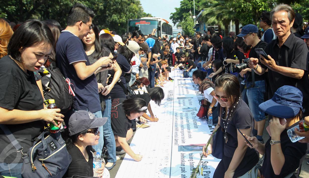 Para pendukung Ahok membubuhkan tandatangan saat aksi di depan Balaikota, Jakarta, Sabtu (13/5). Massa pendukung Ahok menggelar aksi pengumpulan KTP untuk membebaskan Ahok dari jeratan vonis dua tahun penjara. (Liputan6.com/Yoppy Renato)