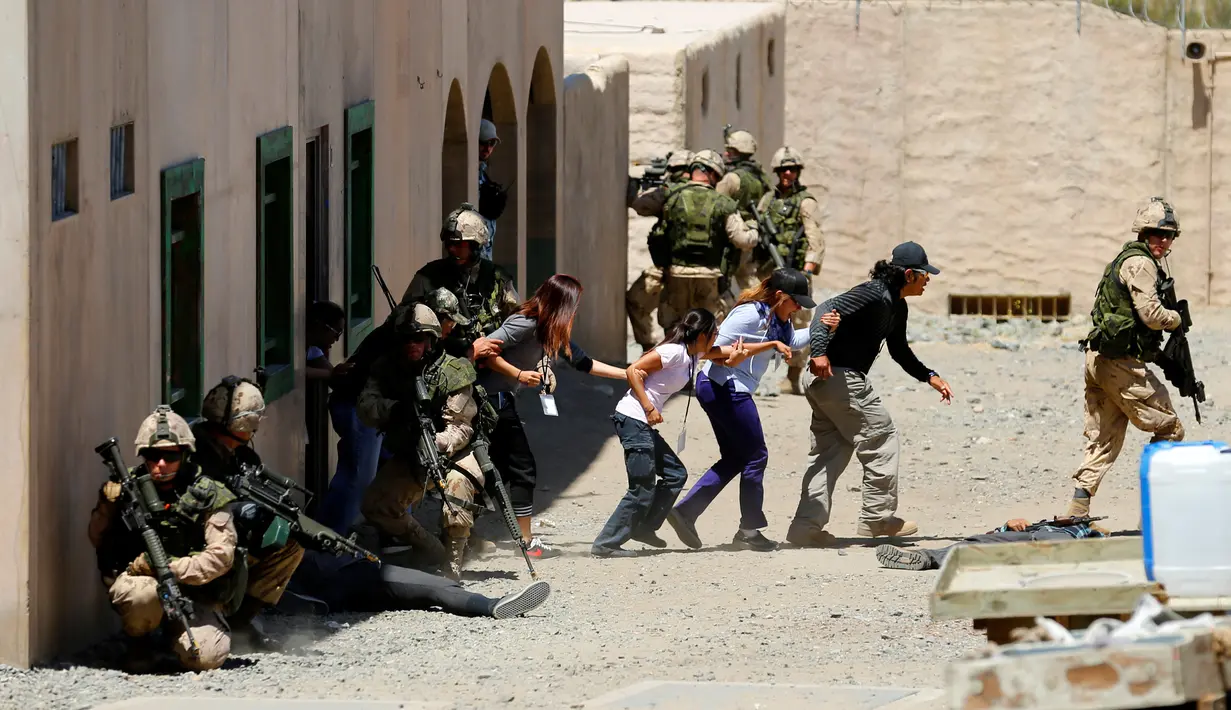 Sejumlah warga sipil dievakuasi ke zona aman oleh tentara Kanada selama operasi ekstraksi non-agresif di sebuah desa dalam simulasi latihan Rim Pasifik (RIMPAC) 2016 di Camp Pendleton, California, Amerika Serikat, (11/7). (REUTERS/Mike Blake)