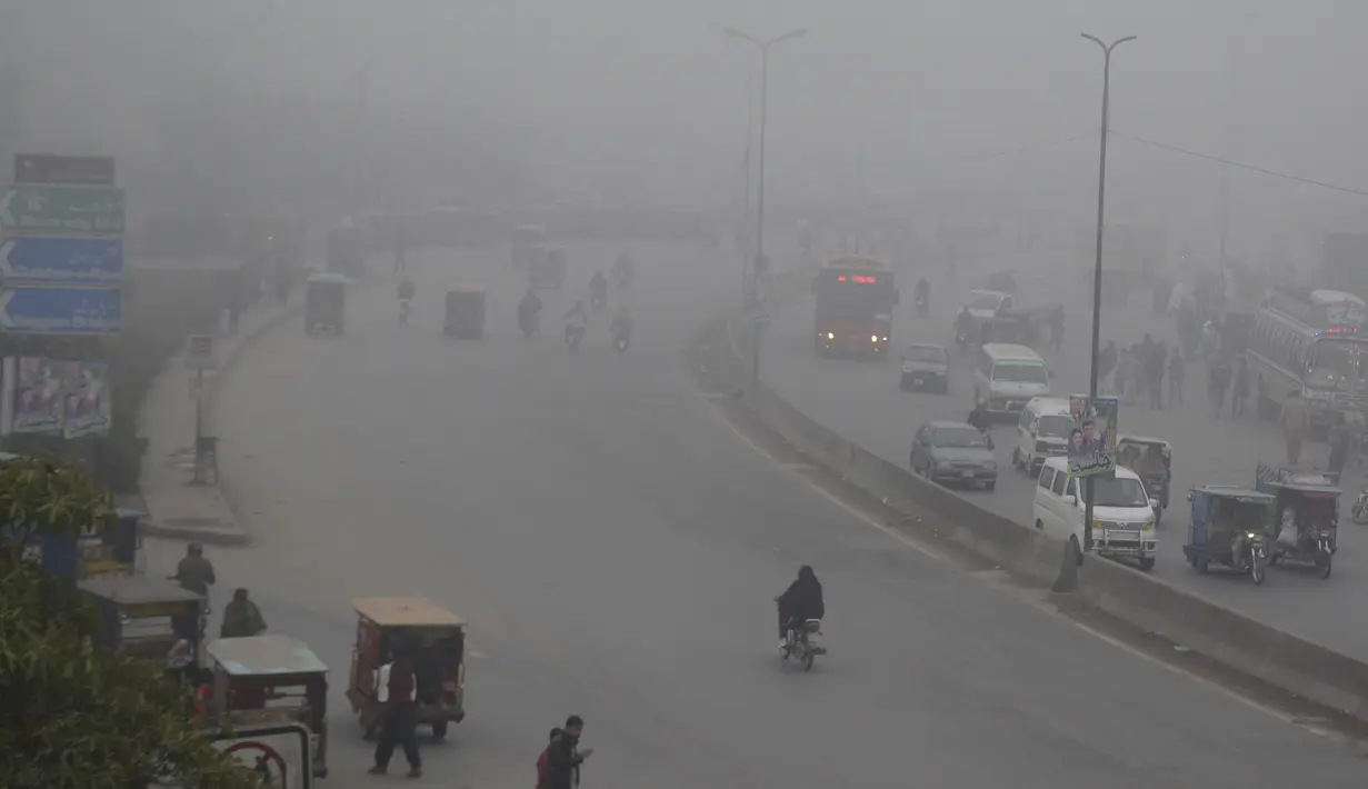 Kendaraan melaju di sebuah jalan di tengah kabut tebal di Kota Lahore, Pakistan timur, pada 13 Desember 2020. Kabut tebal menyelimuti sejumlah kota di Pakistan, sehingga meminimalkan jarak pandang dan mengganggu lalu lintas jalan. (Xinhua/Sajjad)
